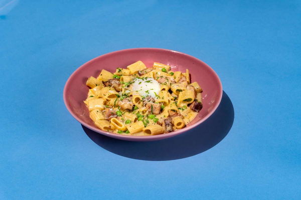 Rigatoni pasta carbonara, bacon, parmesan, farm fresh egg, English peas, black pepper