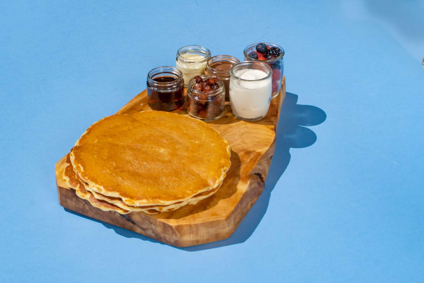 Pancake stacks, topped with toasted hazelnuts, whipped cream, chocolate spread, syrup & butter