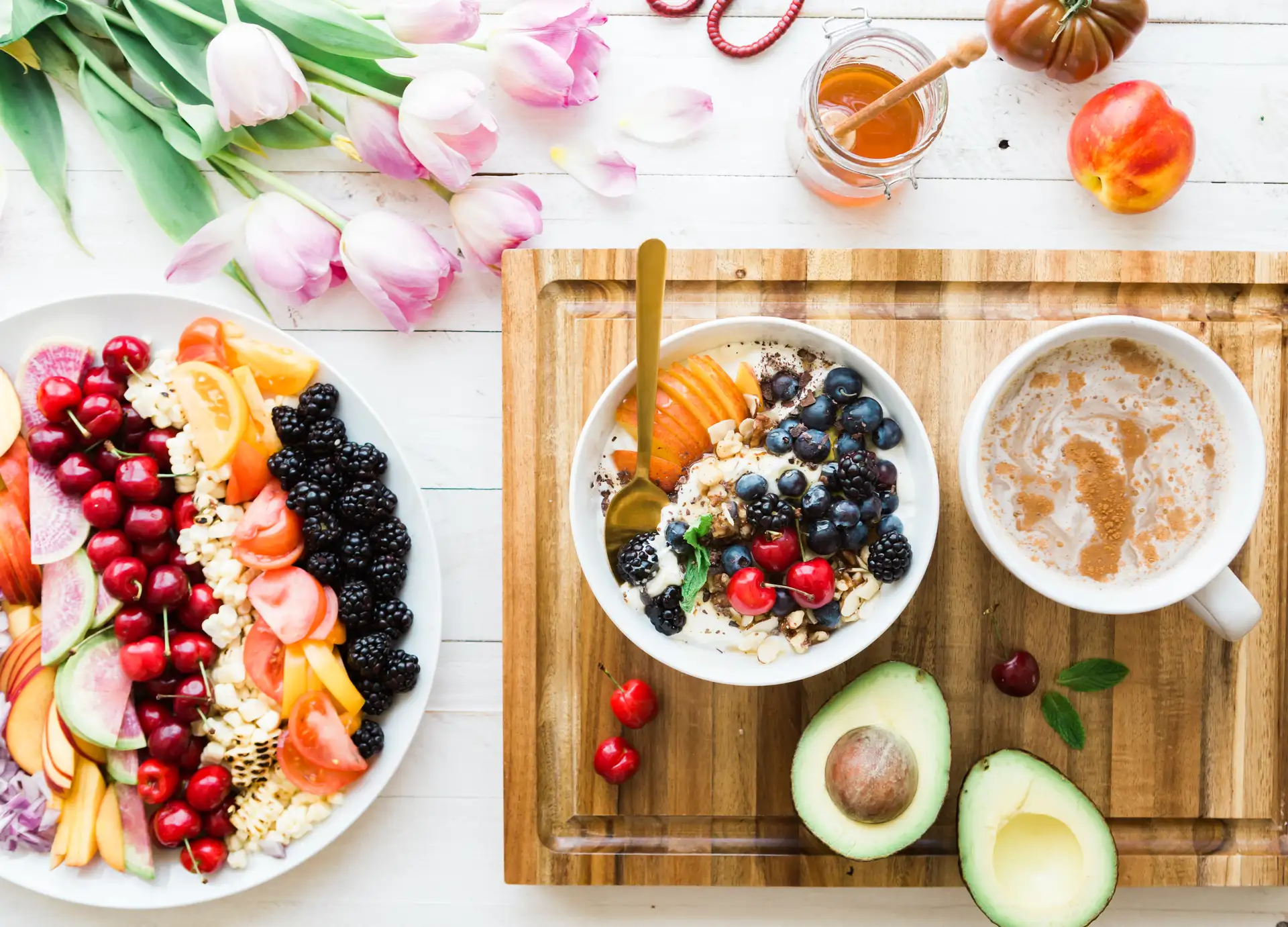 A bowl of oatmeal with a coffee and a platter of fruit